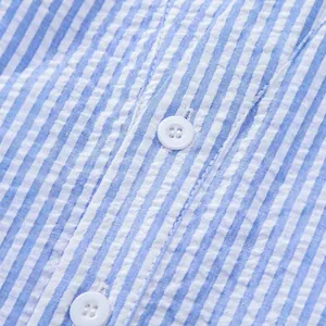 Detailed view of blue and white striped seersucker shirt fabric with white buttons