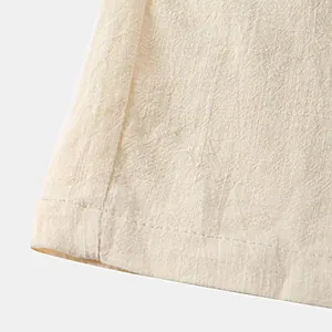 Detailed close-up showing the breathable beige cotton linen fabric texture and stitched hem