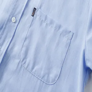 Primer plano del bolsillo de una camisa Oxford azul claro con etiqueta tejida de moda