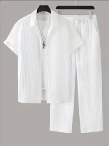 Détail montrant la texture à rayures verticales sur l'ensemble chemise et pantalon blanc.