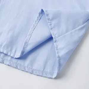 Primer plano detallado que muestra las finas costuras del dobladillo de la camisa azul