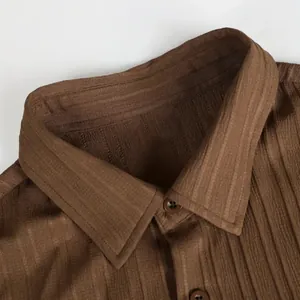 Vue détaillée d'un col de chemise marron à rayures verticales avec fermeture à bouton