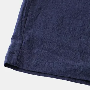 Close-up detail of navy blue cotton fabric texture with professional double-stitched hem