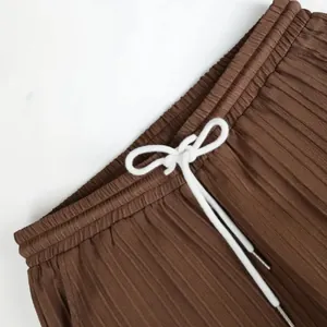 Gros plan d'un pantalon plissé marron avec taille élastique et cordon de serrage blanc
