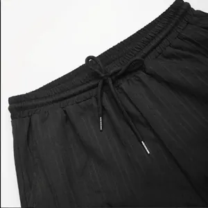 Gros plan du pantalon rayé noir pour homme avec taille élastique et cordon de serrage réglable