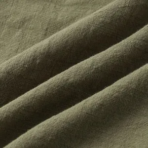 Macro view of olive green cotton fabric texture showing breathable weave and soft drape