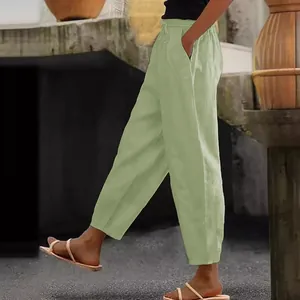 Detail of light green cotton linen casual pants with elastic waist and pockets.