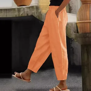 Detailed side view of orange cotton linen casual pants with pockets and elastic waist
