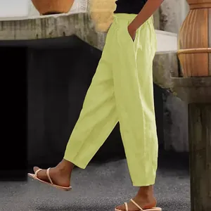 Side view of women's yellow cotton linen pants with pockets and elastic waist