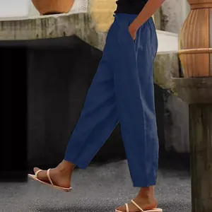 Side view detail of navy blue linen cotton trousers with elastic waist and pockets.