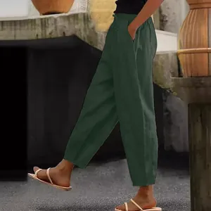 Close-up of dark green cotton linen casual pants with elastic waist and side pockets.