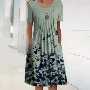 Close-up detail of a sage green midi dress featuring a navy floral print and side pockets.