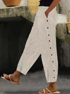 Detalle de los pantalones a rayas de cintura alta para mujer con botones laterales