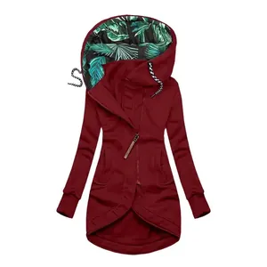 Detailed view of burgundy zip-up hoodie featuring tropical leaf print hood lining.