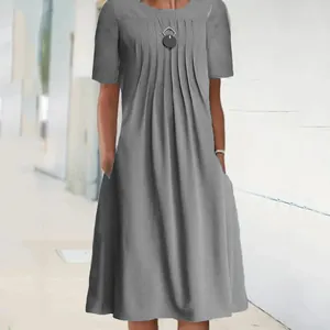 Detail of the grey round neck short sleeve midi dress with pleats and functional pockets