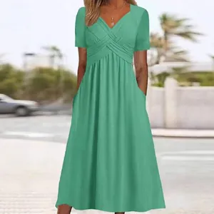 Élégante robe midi verte à col en V, manches courtes et poches latérales pratiques.