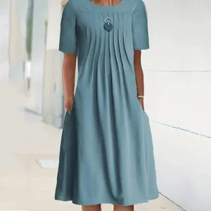 Detail of light blue short sleeve dress showing round neck pleated front and side pockets