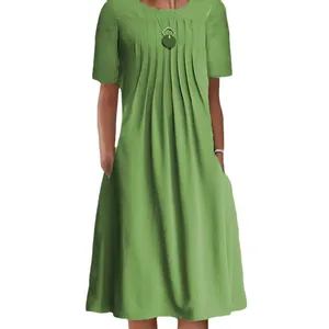 Detail view of a stylish green short-sleeve midi dress with front pleats and side pockets