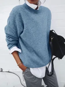 Close-up detail of women's blue knit pullover sweater layered over a white shirt