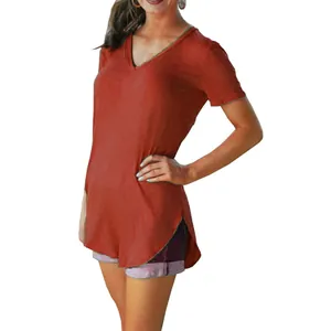 Detail of a woman wearing a rust orange V-neck short-sleeve T-shirt with a curved hem design