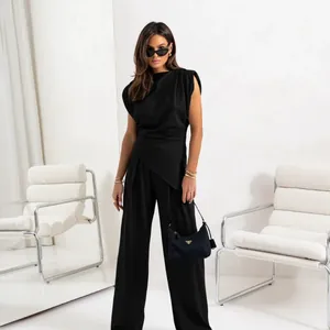 Ensemble chic deux pièces noir avec haut asymétrique sans manches et pantalon large