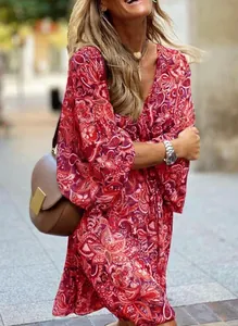 Close-up shot of a bohemian women's red paisley print V-neck summer dress outdoors