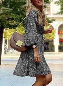 Full view detail of a chic boho paisley print long sleeve mini dress in an outdoor setting