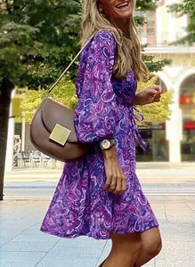 Close-up of purple paisley print summer dress with long sleeves and cinched waist