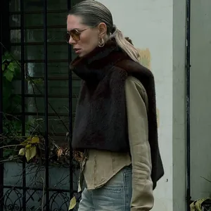 Detalle de un chal de cuello alto de piel sintética marrón para moda de otoño invierno mujer.