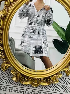 Dettaglio di un abito con cappuccio da donna con stampa a giornale e coulisse regolabile.