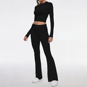 Elegant slim fit black long sleeve crop top and matching flared yoga leggings two-piece set