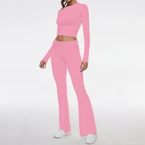 Elegant pink two-piece set with long-sleeve crop top and high-waisted flared pants