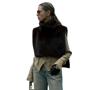 Chaleco de piel sintética marrón oscuro con cuello alto sobre camisa beige para el otoño