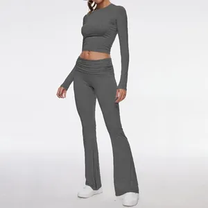 Full view of women's professional grey long sleeve crop top and flared pants yoga set