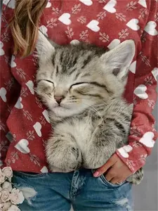 Détail d'un sweat à col rond rouge avec imprimé chaton mignon et cœurs