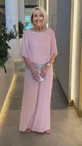 Elegant pink two-piece set featuring sequined neckline and wide-leg trousers on model