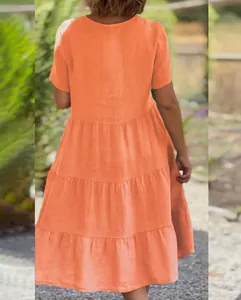 Gedetailleerd achteraanzicht van een oranje zomerjurk met een zwierige gelaagde rok