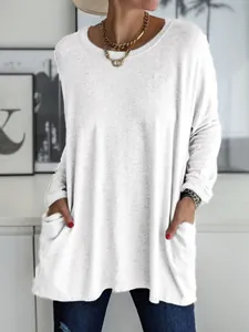 Détail d'un t-shirt blanc à manches longues ample avec poches avant fonctionnelles