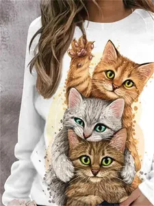Gros plan d'un imprimé graphique de trois chatons mignons sur un sweat-shirt blanc uni.