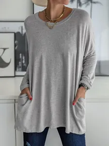 Détail d'un t-shirt gris à manches longues pour femme avec poches latérales pratiques.