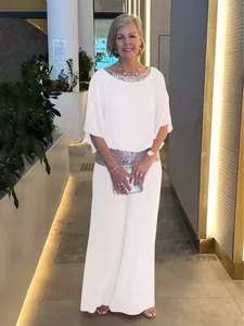 Elegant white two-piece set with sequin trim, batwing sleeves and wide-leg trousers for women.