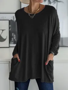 Détail d'une tunique noire ample à manches longues avec poches avant pour un look décontracté