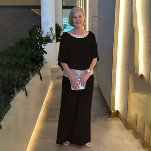 Elegant black two-piece set featuring a sequined batwing sleeve top and wide-leg pants