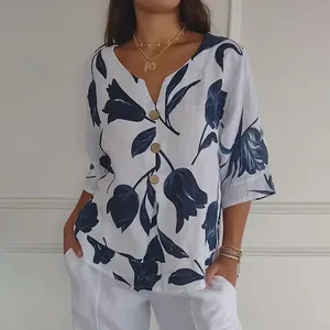 Détail d'une blouse en coton et lin à col en V avec des motifs de tulipes bleues et boutons