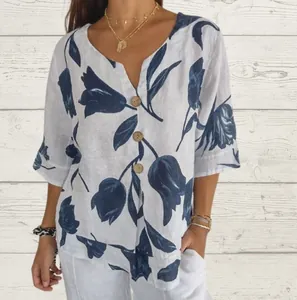 Gros plan d'une blouse en coton et lin blanc avec imprimé tulipes bleues et boutons