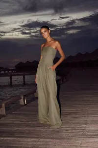 Combinaison bustier élégante vert olive à jambes larges dans un décor de station de luxe