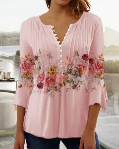 Close-up of pink floral print V-neck blouse with white buttons and pleated details.