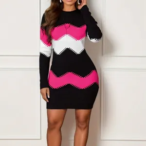 Detail of long sleeve knit bodycon dress with vibrant pink and black chevron pattern