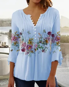 Detail of light blue V-neck blouse with floral print and pleated button design
