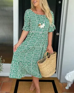 Beautiful green polka dot midi dress with ruffle sleeves styled with a straw tote bag